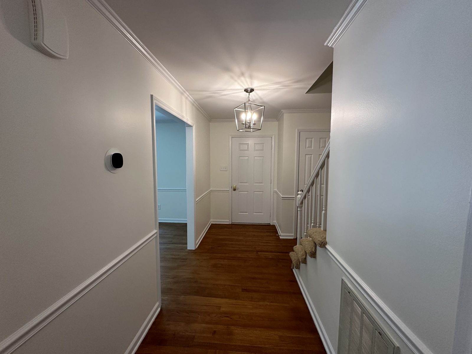 Hallway with fresh wall color above white wainscoting and painted doors — interior painting by Roca’s Painters of Mebane, NC