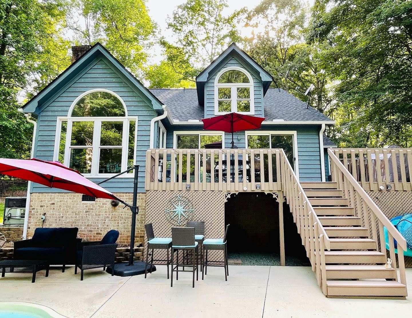 Two-story blue home with painted deck stairs and trim — exterior painting by Roca’s Painters of Mebane, NC
