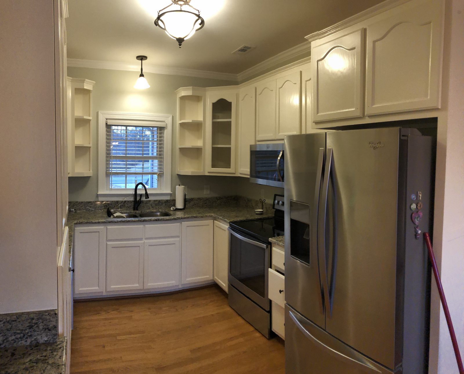 Small kitchen with arched cabinet doors refinished in a soft white — cabinet painting by Roca’s Painters of Mebane, NC