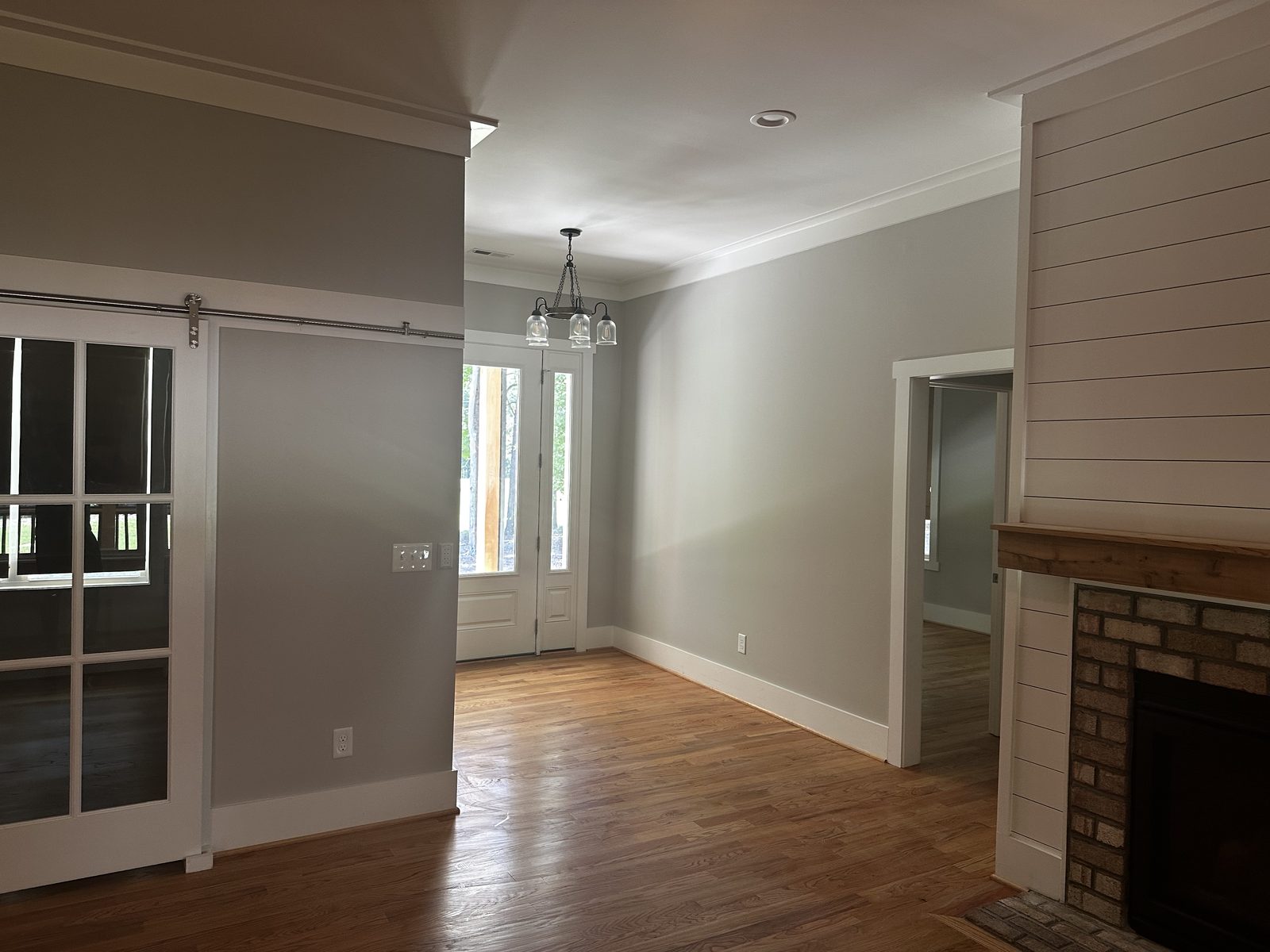Open dining and living area with painted shiplap fireplace wall and white trim — interior painting by Roca’s Painters of Mebane, NC