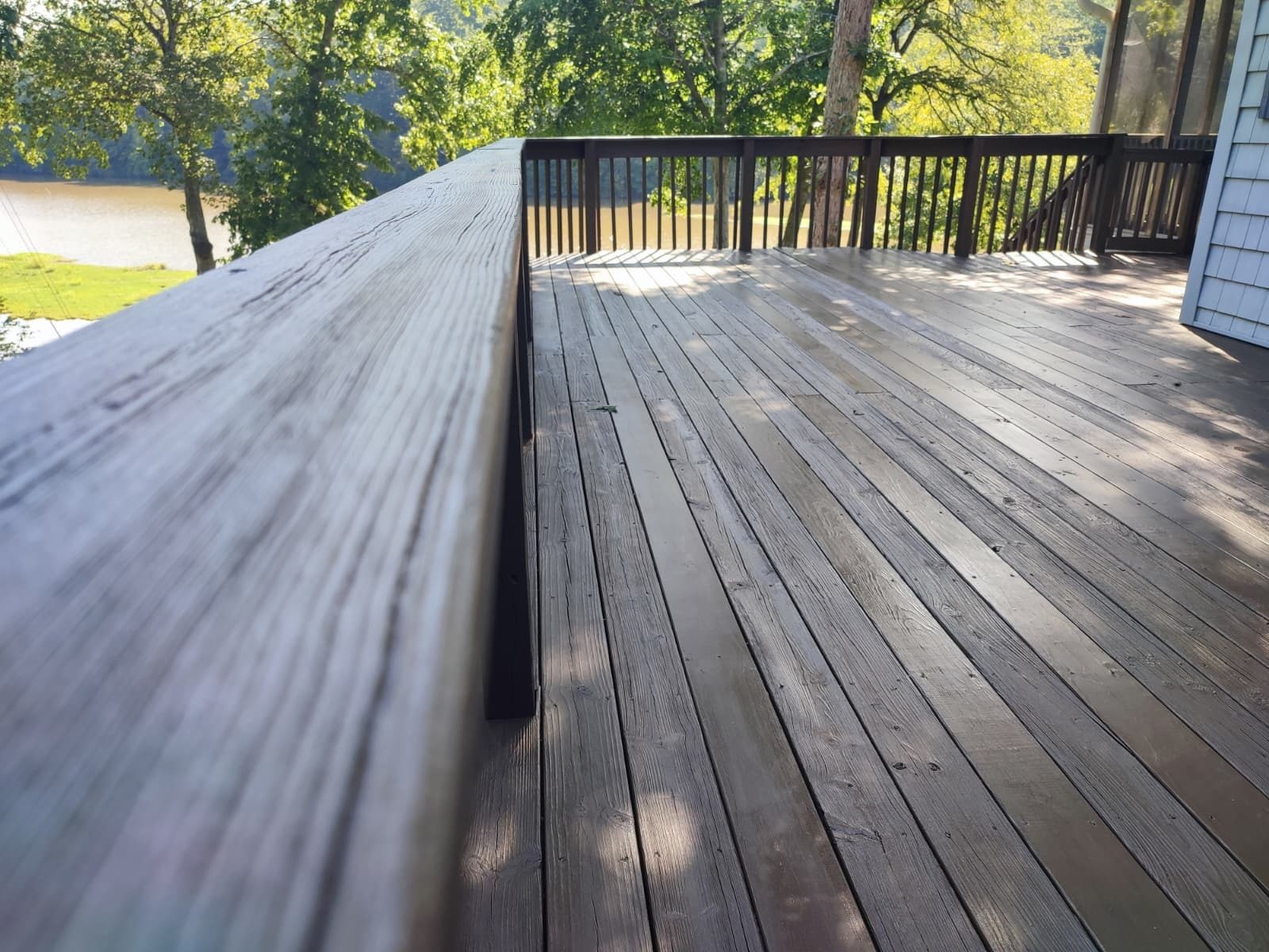 Deck boards finished in a dark semi-transparent stain — deck restoration by Roca’s Painters of Mebane, NC