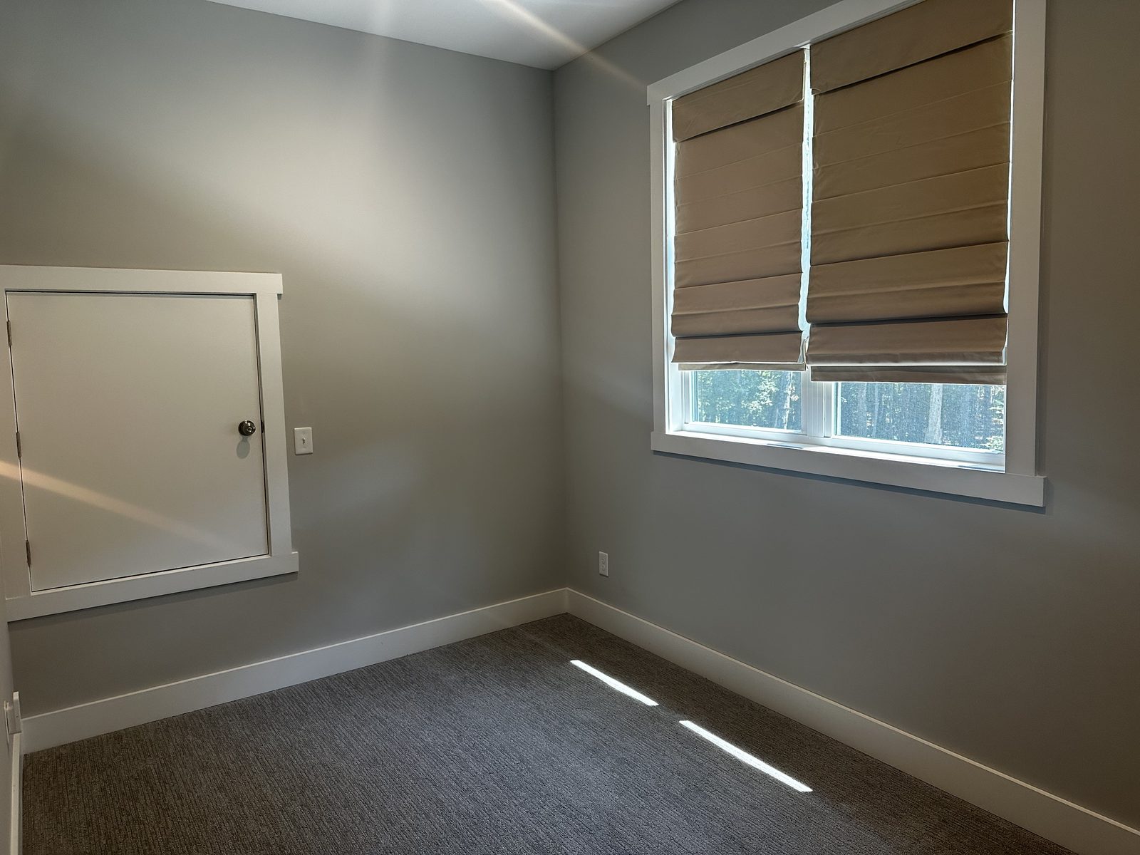 Bedroom walls painted a warm greige with white trim and window casing — interior painting by Roca’s Painters of Mebane, NC