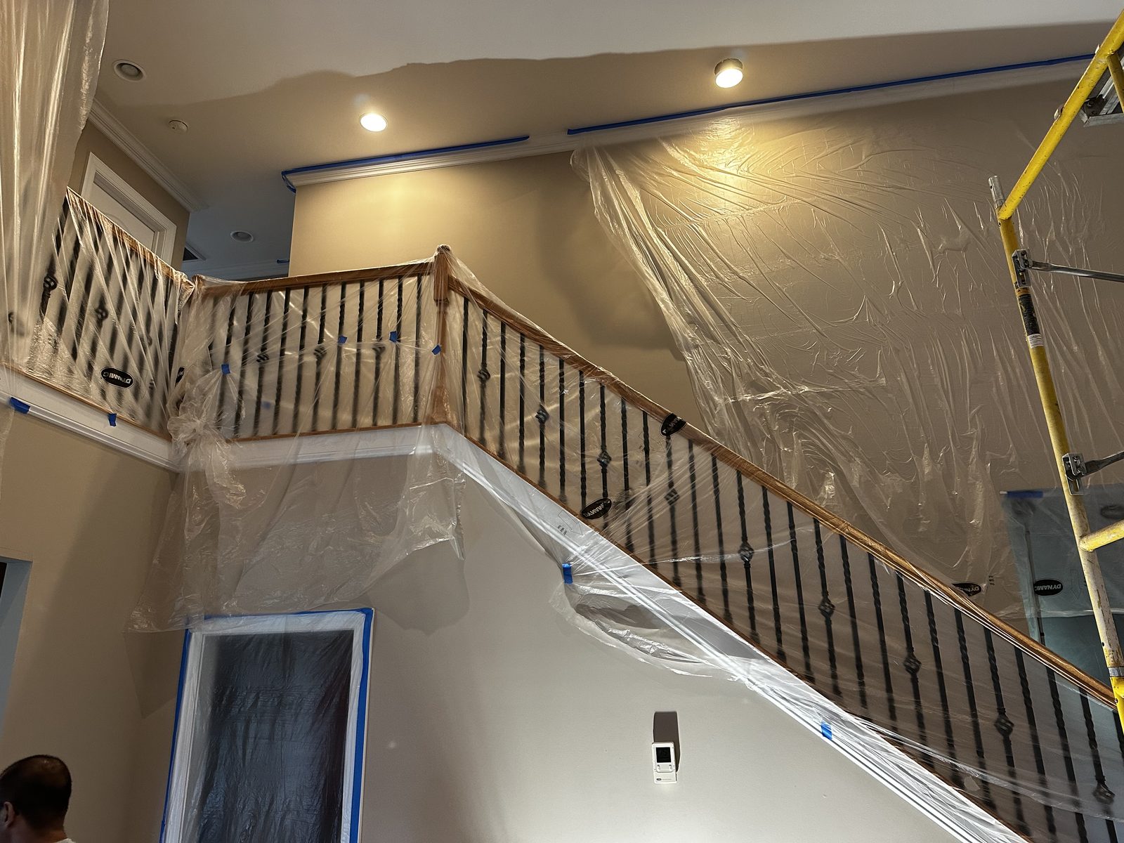 Stairwell railings and floors masked with plastic before interior painting begins — interior painting by Roca’s Painters of Mebane, NC