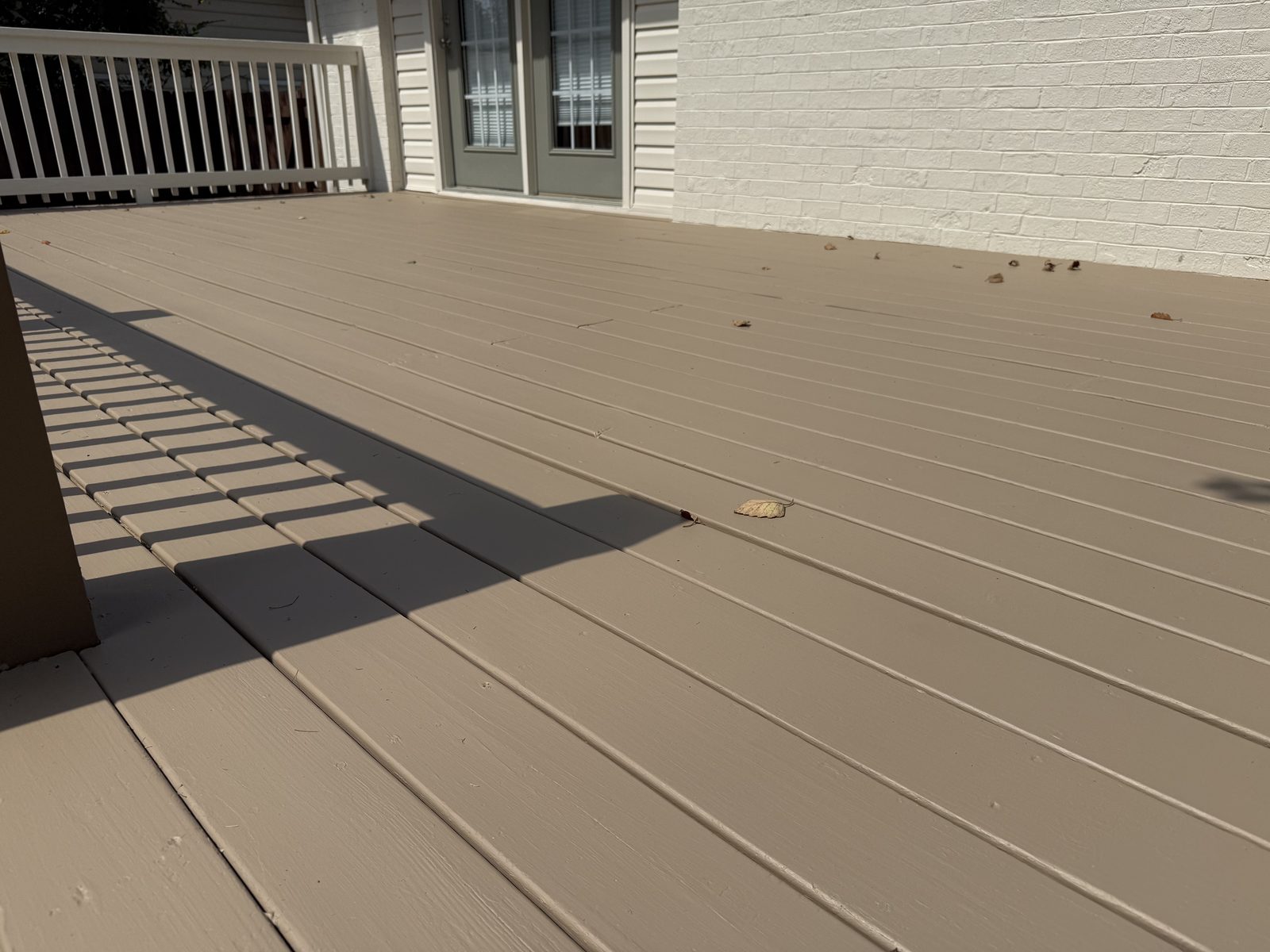 Close view of freshly painted tan deck boards — deck restoration by Roca’s Painters of Mebane, NC
