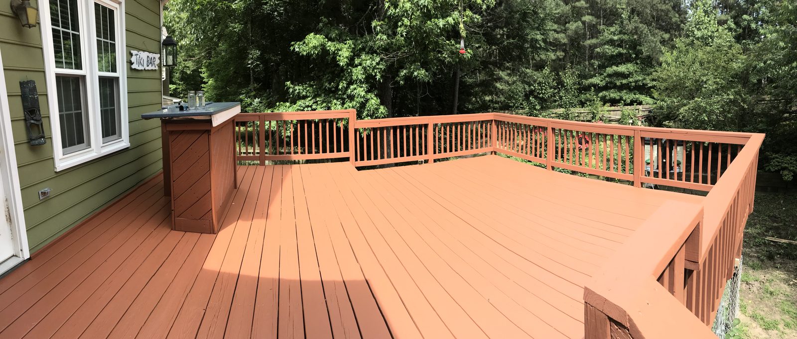 Large wraparound deck stained in a warm cedar color — deck restoration by Roca’s Painters of Mebane, NC