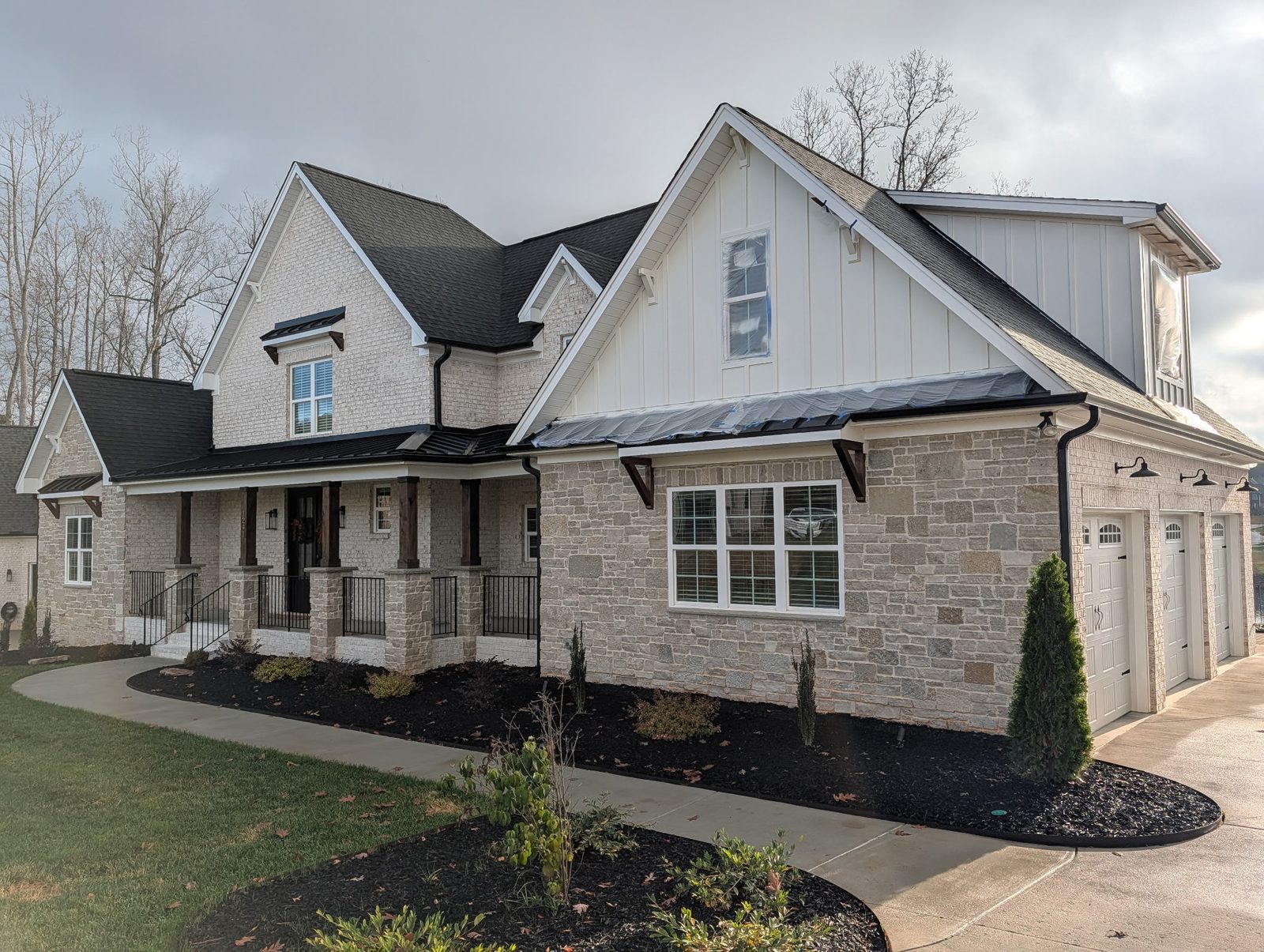 Craftsman home with painted board-and-batten siding and stone front — exterior painting by Roca’s Painters of Mebane, NC