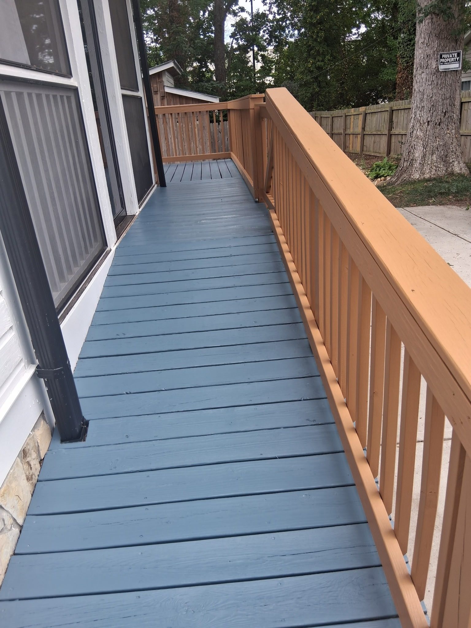 Long deck walkway with gray painted boards and tan railing — deck restoration by Roca’s Painters of Mebane, NC