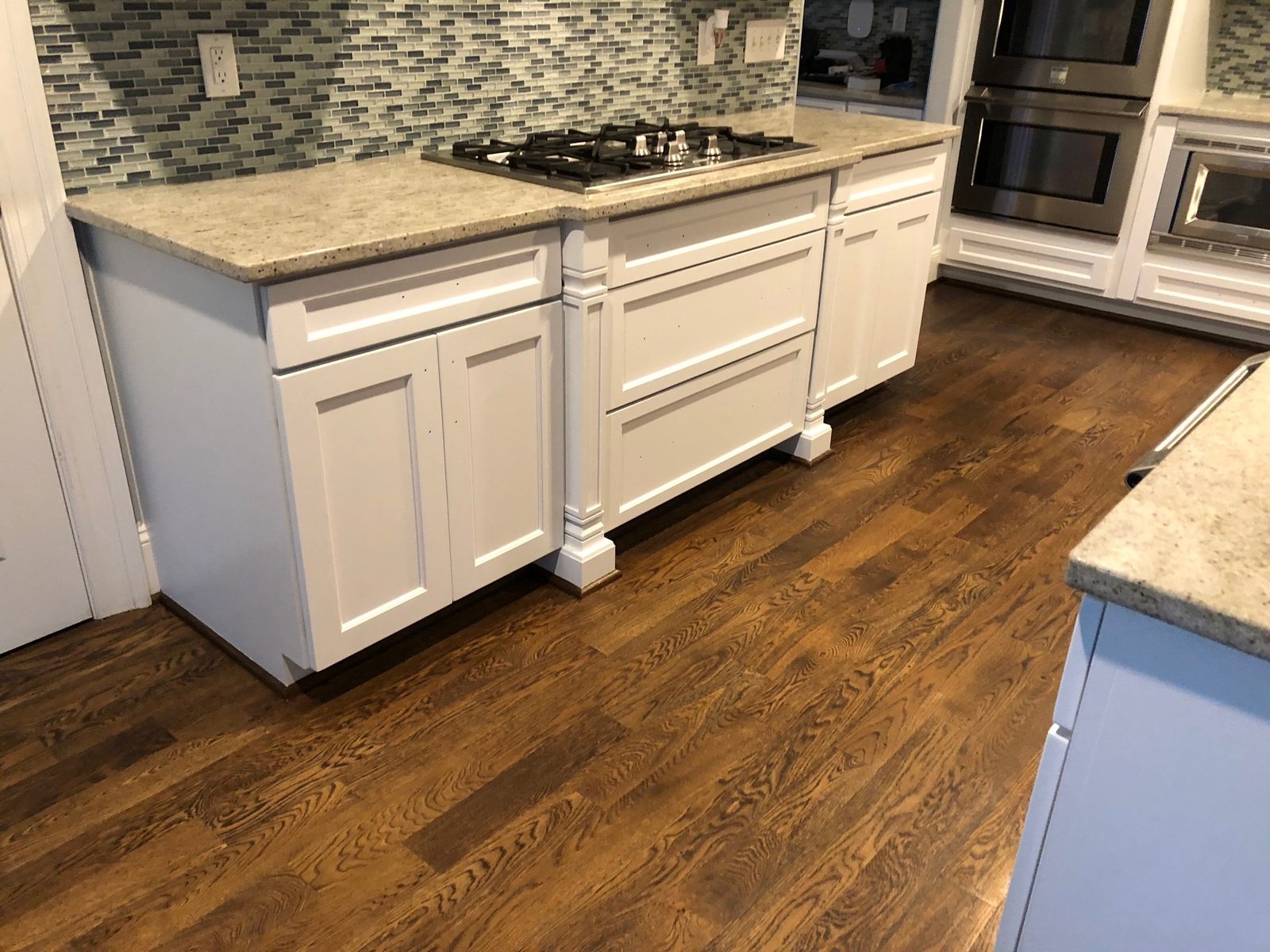 Island and base cabinets sprayed white with crisp panel edges and turned legs — cabinet painting by Roca’s Painters of Mebane, NC